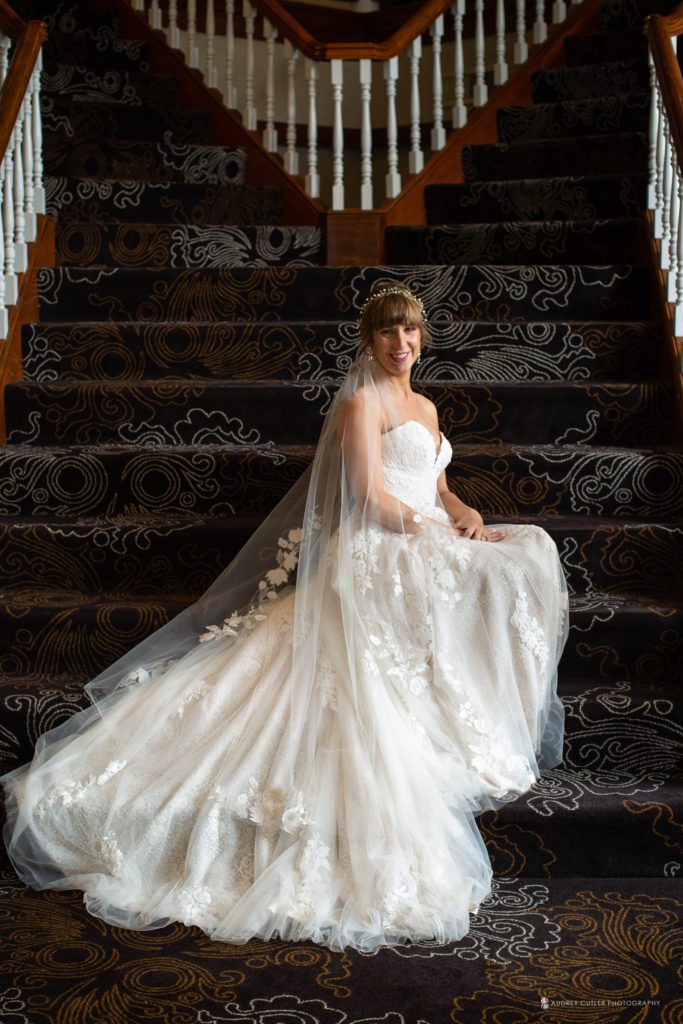 Bride-sitting-on-staircase-of-colonial-hotel-gardner-ma