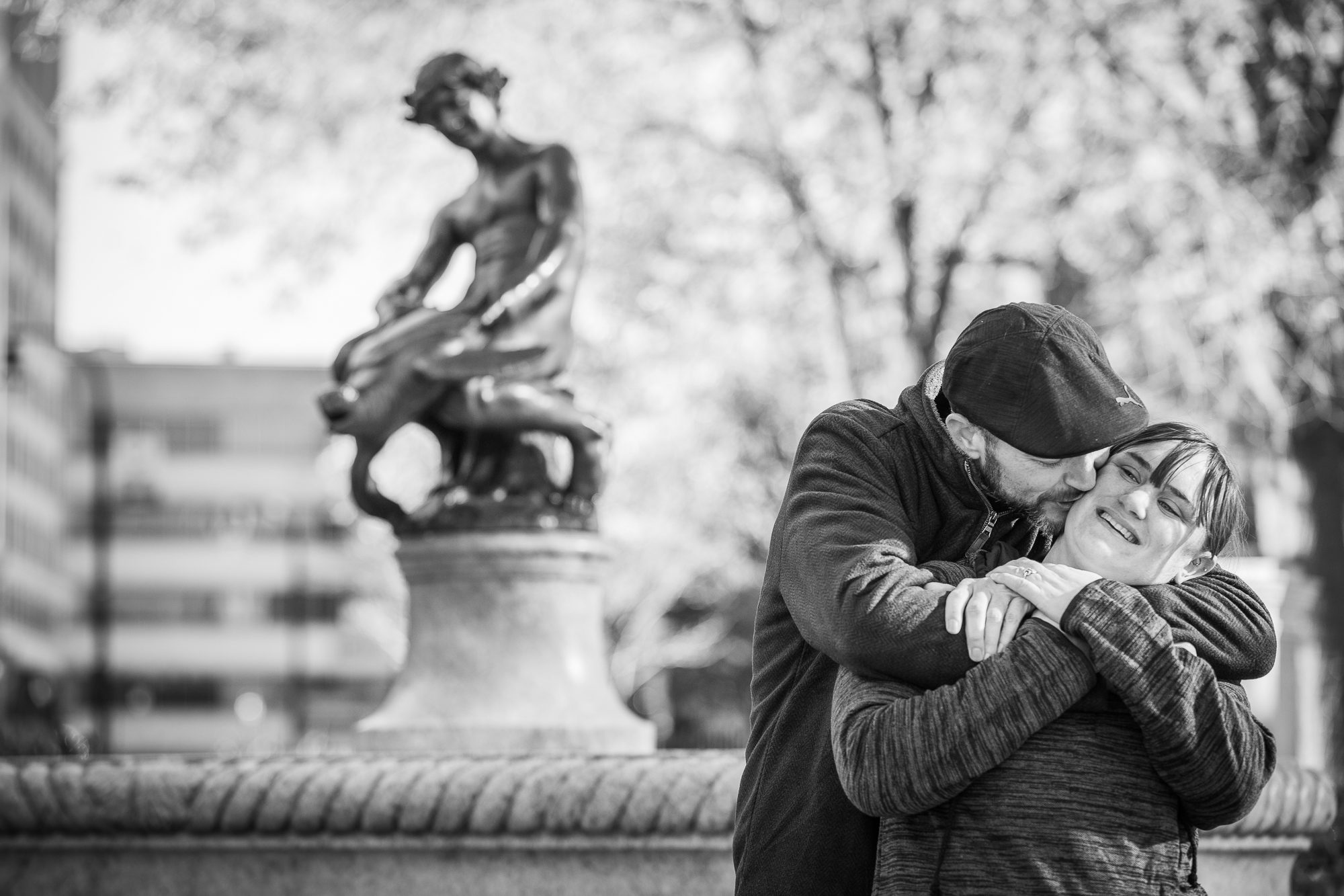 couple_snuggling_infront_of_Worcester_turtleboy_statue_engagement_photos