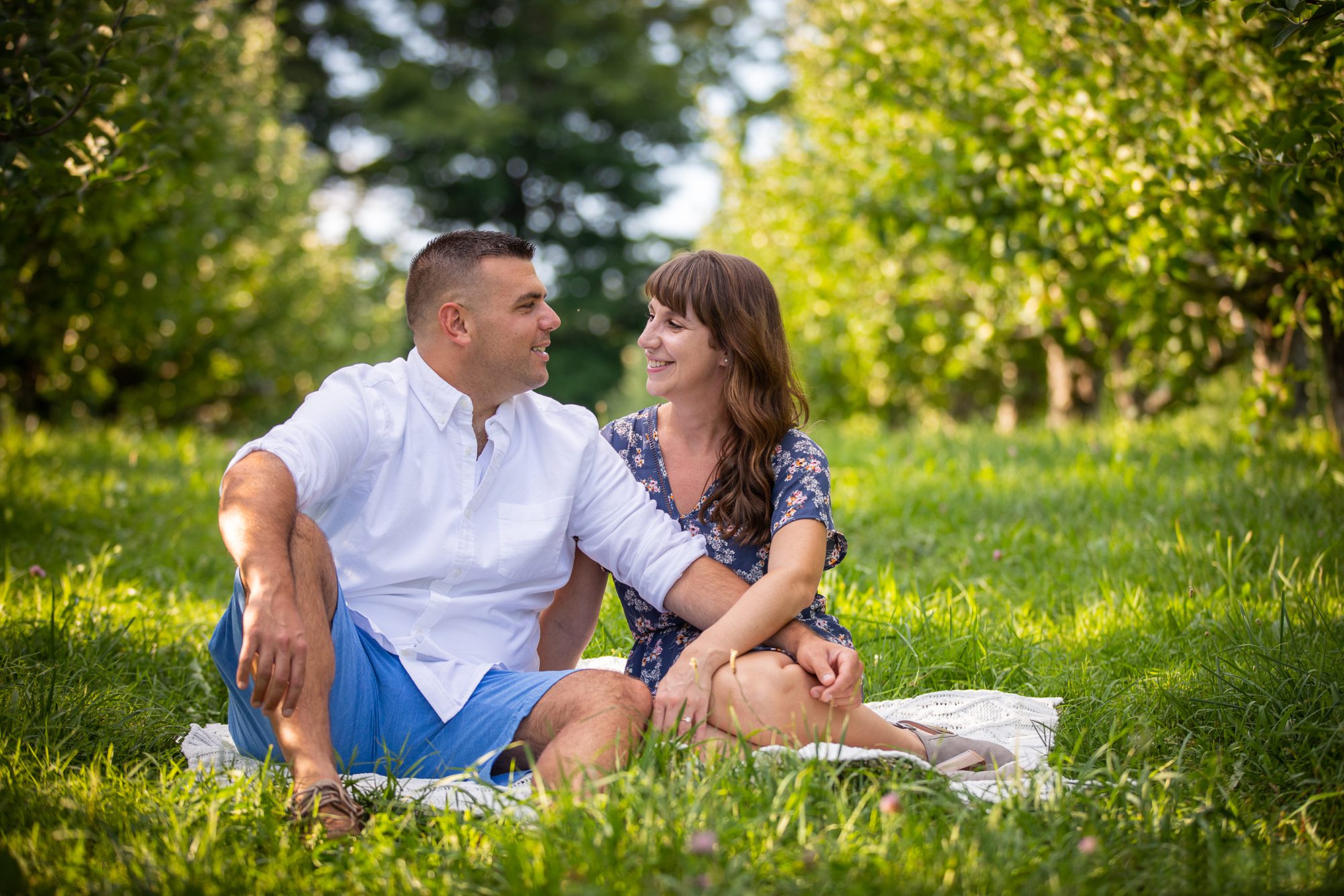engagement_couple_sitting_in_apple_orchard