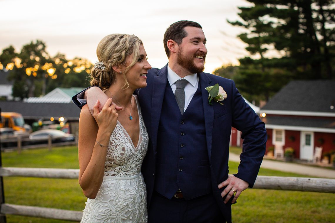groom-with-arm-around-bride-at-sunset-smolak-farms-andover-ma