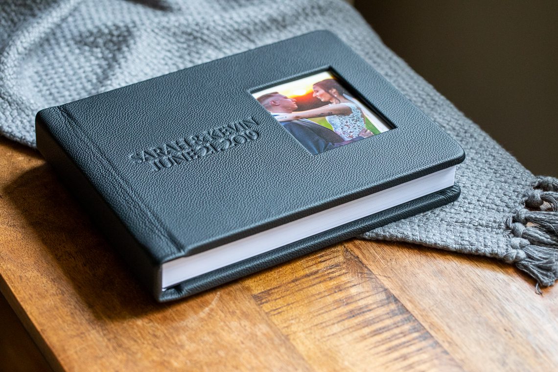 black-leather-wedding-album-with-cameo-cover-on-table-massachusetts-Prints-vs-Digital-Files