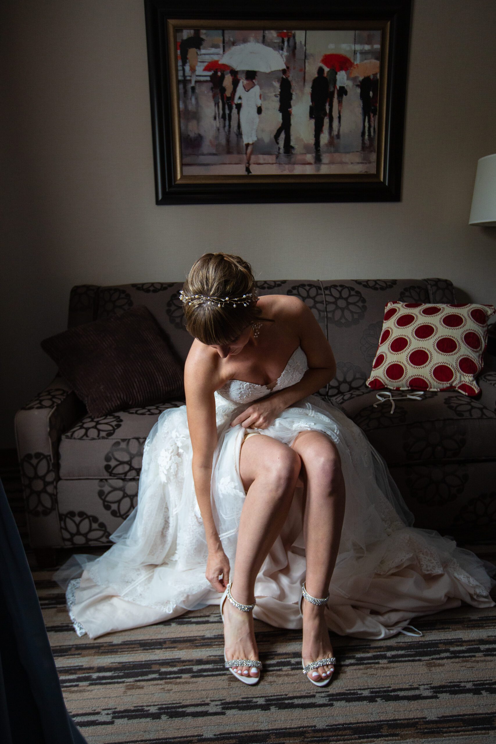 Bride putting shoes on in gorgeous window light at colonial-hotel-wedding-massachusetts