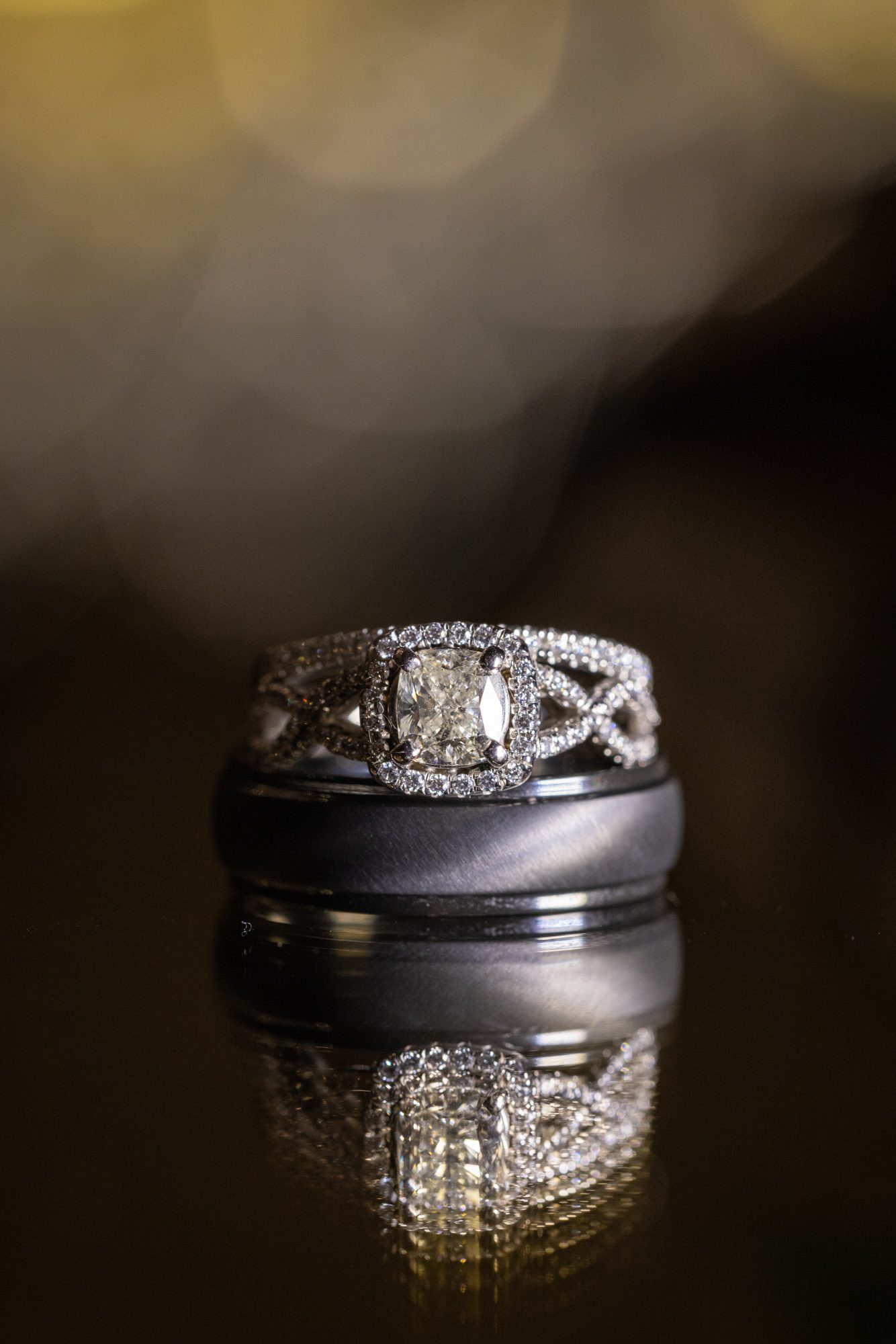 Up close Photos of rings and wedding bands on mirrored surface at colonial-hotel-wedding-gardner-ma