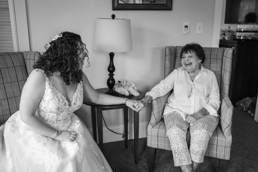 bride holds her grandmother's hand and laughs together wedding photo documentary  How to Plan Your Wedding Without Losing Your Mind 