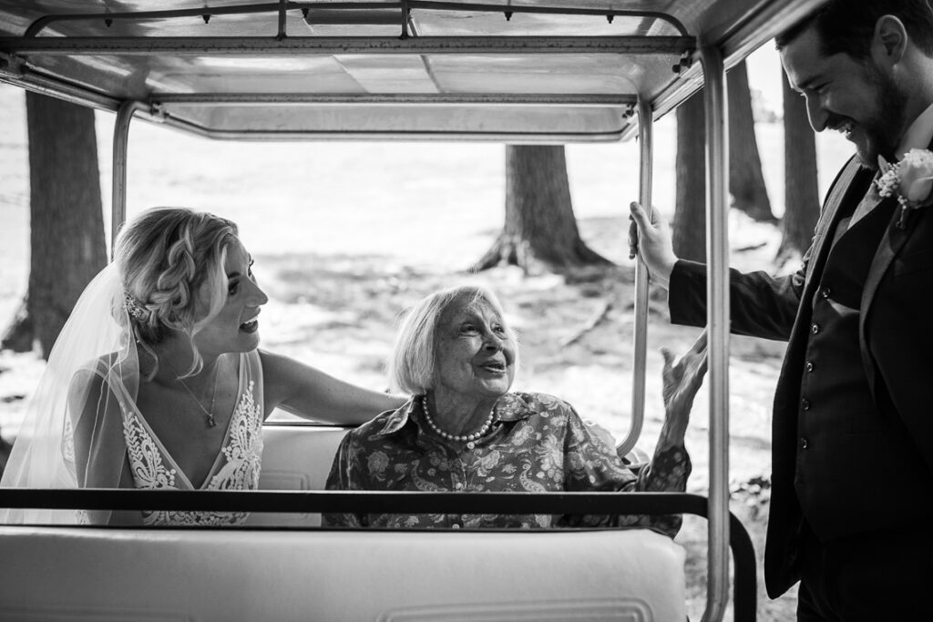Why Little Moments Matter on Your Wedding Day- bride-sitting-with-grandmother-in-golf-cart-smiling-at-groom-worcester-ma Unscripted authentic photography
