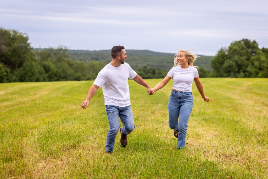 couple run through field Saint Joseph’s Abbey Engagement Spencer MA