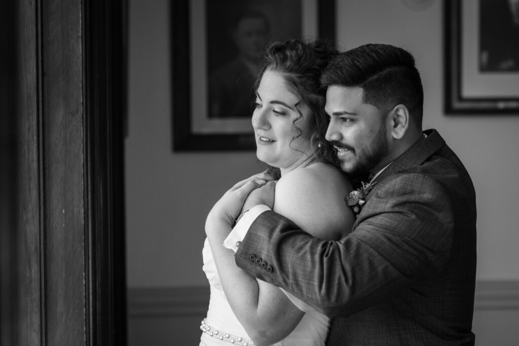 black and white image of couple looking out window. Learn how to book wedding vendors in the age of AI with confidence and clarity, avoiding common pitfalls and fake businesses. 
